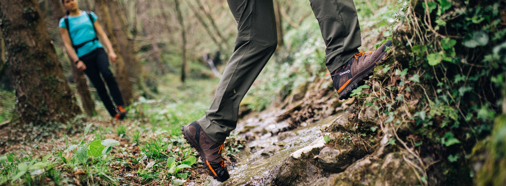 mężczyzna w butach GORE-TEX przechodzi przez strumień