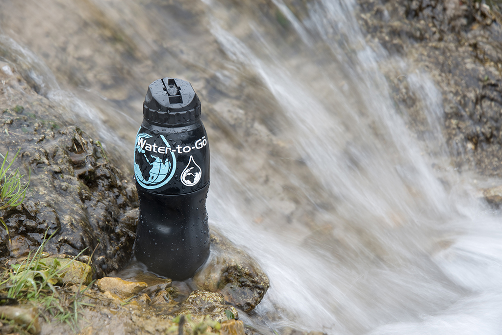 Czarna butelka z filtrem Water-to-Go w tle płynąca woda