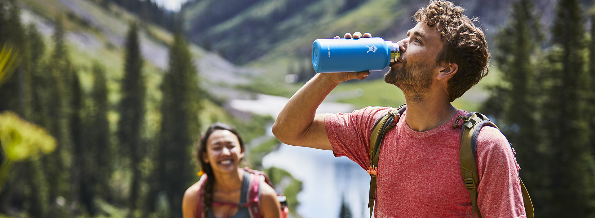 mężczyzna pijący z butelki hydroflask niebieskiej
