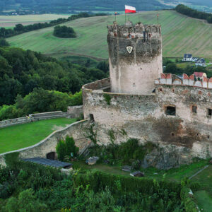 zdjęcie ruin zamku z lotu ptaka, na szczycie wieży biało-czerwona flaga